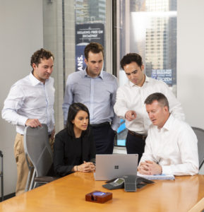 Spire Capital team members looking at a laptop